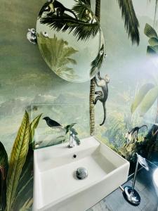 a bathroom with a white sink and a palm tree mural at Your Archipelago Dream On Ingarö in Värmdö +19 photos