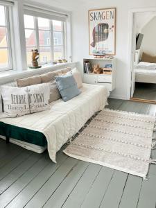 a bedroom with a large bed with pillows on it at Live In Classic Skagen House In Skagen's Heart in Skagen +24 photos