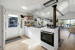 a kitchen with white cabinets and a stove top oven at Idyllic Gem On Als Odde With Activities in Hadsund