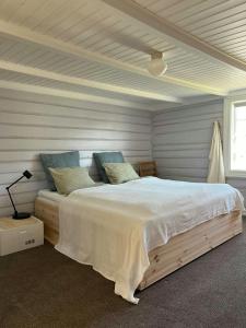 un dormitorio con una cama grande en una habitación en Idyllic Farmhouse From 1840 With Sea View In Spind, en Farsund