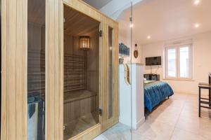 Habitación con nevera y dormitorio con cama. en Cocon Privé avec Jacuzzi & Sauna, en Reims