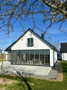 un edificio blanco con muchas ventanas en Traditional Farmhouse In The Heart Of Österlen, en Gärsnäs 11 fotos más