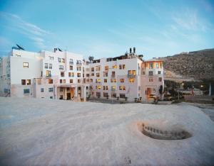 a large white building in front of a building at Mövenpick Resort Petra in Wadi Musa