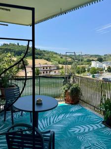 un patio con tavolo e sedie su un balcone di IL GIARDINO FIORITO Luxury Guest House B & B a Cesena
