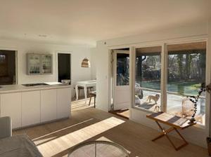 a living room with a kitchen with a dog on the patio at Charming Cottage Close To Smidstrup Beach in Gilleleje
