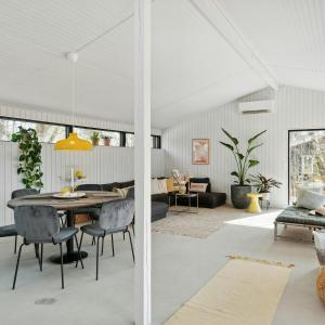 a dining room and living room with a table and chairs at Relaxed Lifestyle And Luxury In Melby in Melby