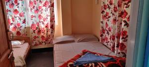 a small bed in a small room with curtains at Tranquil Hill Top Homestay in Kalimpong +2 photos