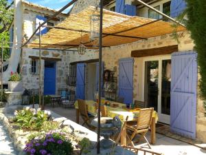 a patio with blue shutters and a table and chairs at La Bergerie in Saint-Jeannet