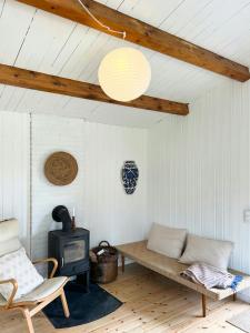 a living room with a bench and a stove at Summer House Near Ahl Beach And Ebeltoft in Ebeltoft
