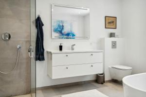 a white bathroom with a sink and a toilet at Enjoy Møn From Historic House in Stege