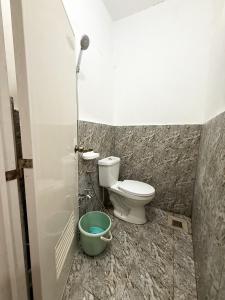 uma casa de banho com um WC e um balde verde em Lees Transient Unit 5 em Digos