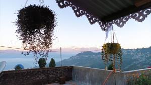 a balcony with a view of the water and mountains at Banabas Homestay in Darjeeling