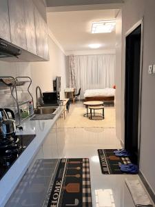 a kitchen with a counter and a living room at The City escape Sabaki green estate - 15 minutes to JKIA and SGR in Marimbeti