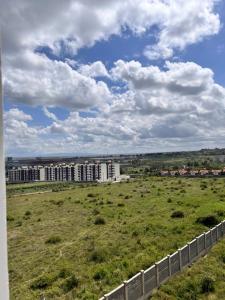 a large field with buildings in the background at The City escape Sabaki green estate - 15 minutes to JKIA and SGR in Marimbeti