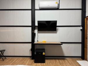 a wall with a desk with a computer on it at บ้านอินทผลัม รีสอร์ท in Ban Na Lao