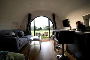 a living room with a couch and a table at Lochend Pods - Deas Pod in Inverlael