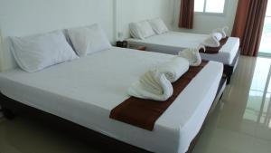 two beds in a hotel room with towels on them at Bottle Beach 2 Bungalows in Bottle Beach