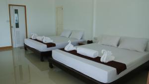 two beds with white towels on them in a room at Bottle Beach 2 Bungalows in Bottle Beach