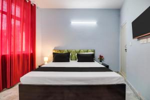 a bedroom with a large bed with a red curtain at Hotel O Blue moon in New Delhi +21 photos
