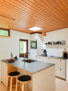 HøjbyにあるAuthentic 60'S Summer House By Ellinge Lyngの白いキャビネットと木製の天井が備わるキッチン