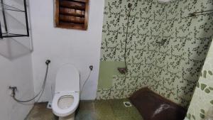 a small bathroom with a toilet and a shower at Shantam Homestay - Peace has an address now! in Cheruthuruthi +35 photos