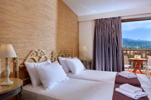 ミラトスにあるVasia Villasのベッド2台とバルコニーが備わるホテルルームです。