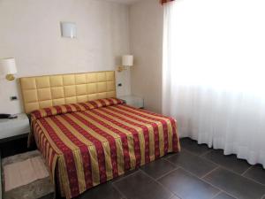 マントヴァにあるHotel Dante Residenceのベッドルーム1室(赤と黄色の毛布付きのベッド1台付)