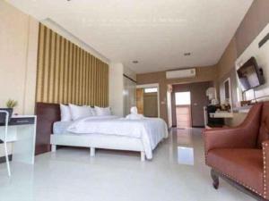 a bedroom with a white bed and a red couch at Med Room Korat in Ban Pra Dok