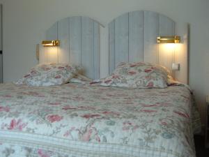a bedroom with a large bed with two pillows at Le Parasol in Ars-en-Ré