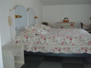 a bedroom with a bed with a floral bedspread at Le Parasol in Ars-en-Ré