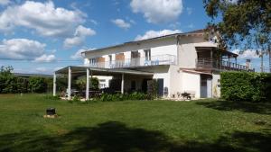 una grande casa bianca con un ampio cortile di Logis Hôtel Restaurant La Borie a Saint-Geniès