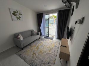 een woonkamer met een bank en een tafel bij D' Ehsan Homestay & Chalet in Kuala Terengganu