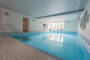 a large swimming pool with a blue tile floor at Hotel Haus Erholung in Cochem