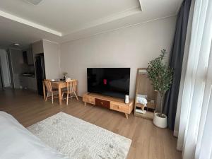 a living room with a flat screen tv and a table at D'heights L5 Condo in Angeles