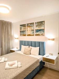 a bedroom with a bed with three paintings on the wall at Imedio Coral Apartment Aviatiei in Bucharest