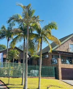 dos palmeras frente a un edificio en Emoyeni Guest House, en Nelspruit
