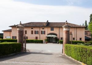 an entrance to a large building with a gate at Hotel Santo Stefano in Campagnola Emilia