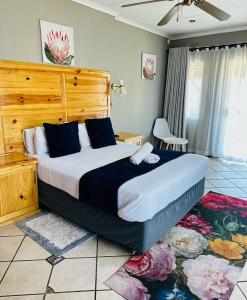 Un dormitorio con una cama grande con cabecero de madera. en Emoyeni Guest House, en Nelspruit