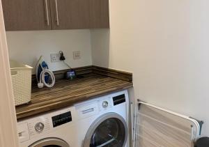 a washer and dryer in a kitchen with a counter at Cotswolds Lakeside Home, Summer Lake in South Cerney