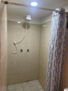 a bathroom with a shower with a shower curtain at Cuarto Longanizo -privado, céntrico- Casa de Teru in Tapachula +2 photos