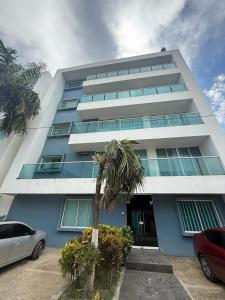 a tall building with a palm tree in front of it at Brisa del Mar in Cartagena de Indias