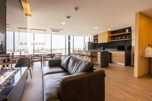 a living room with a couch and a dining room and kitchen at Eazy Stay in Tijuana