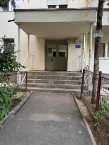 a building with a gate and stairs leading to a door at Imedio Coral Apartment Aviatiei in Bucharest