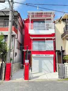 寝屋川市にある一棟貸しの宿 貸別荘 寝屋川ハウス NEYAGAWA HOUSE! for up to 10 people, 3 min walk from Keihan Kayashima Station, 京阪電車 萱島駅から徒歩3分, キーボックスの暗証番号はご予約後に宿からのメッセージ欄にてご確認下さい,の赤い建物