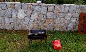 a plastic bag sitting next to a piano in front of a stone wall at Holiday Home Skadar Lake in Arbneš