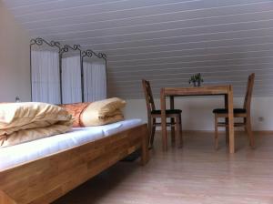 1 dormitorio con 1 cama, mesa y sillas en Appartement Kirchenblick en Bad Birnbach