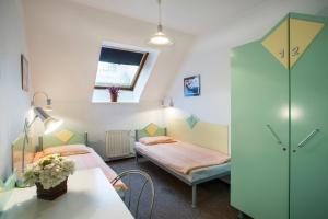 Habitación con 2 camas, mesa y ventana en MP Hostel Budapest en Budapest