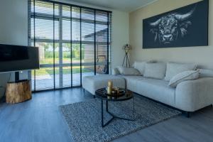 a living room with a couch and a table at Sunray Anker in Molenschot