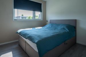 a bed in a bedroom with a window at Sunray Anker in Molenschot +15 photos