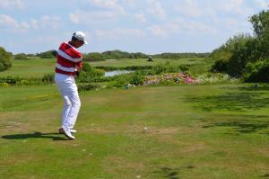 a man playing golf on a golf course at Hotel Hansa in Wenningstedt